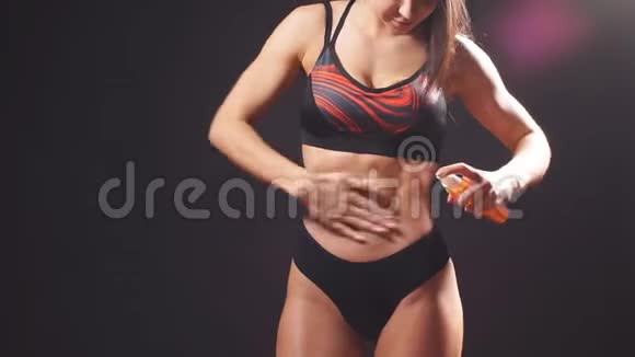 女孩运动的外表从一瓶身体油中喷出来体育概念视频的预览图