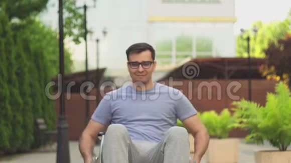 一个戴着轮椅眼镜看着摄像机的残疾人的肖像视频的预览图