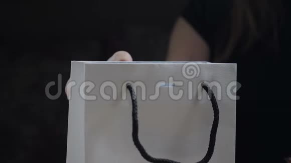包裹礼物女性手指在现盒上系红色丝带蝴蝶结特写镜头女人手上装礼物视频的预览图