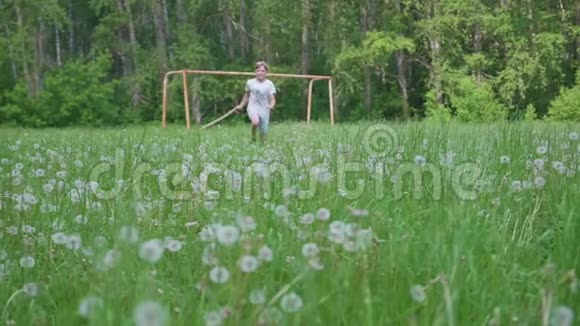 那个年轻人跑过蒲公英的田野蒲公英的种子在空中飞舞在公园里做运动视频的预览图