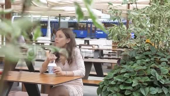 有人在看一个女孩在街上的咖啡馆里吃冰淇淋视频的预览图
