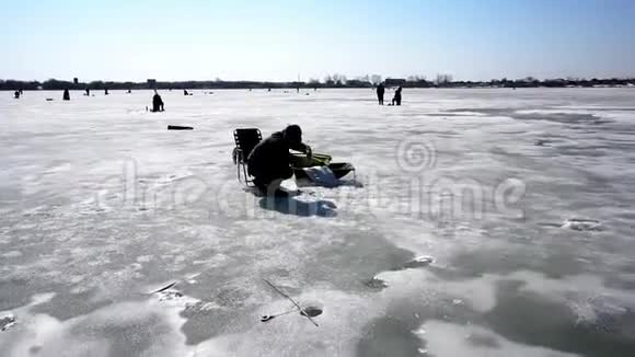 渔人为冬季冰上垂钓和冬季运动捞鱼视频的预览图