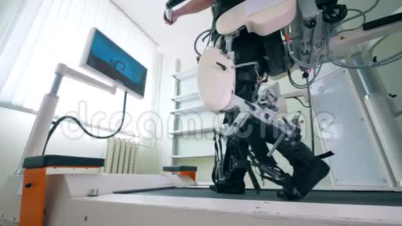 残疾人士正在训练他的腿在跑步轨道上用于康复的电子医疗机器人视频的预览图