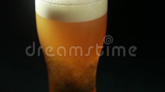 啤酒倒在一个黑色背景的杯子里视频的预览图