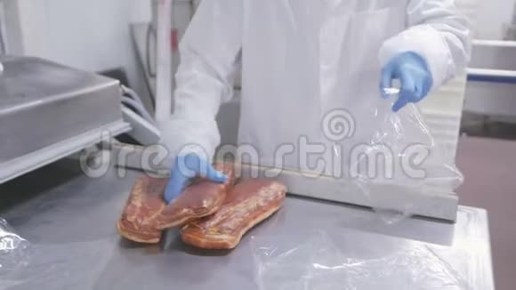 肉类加工工人用真空包装方式包装熏肉视频的预览图
