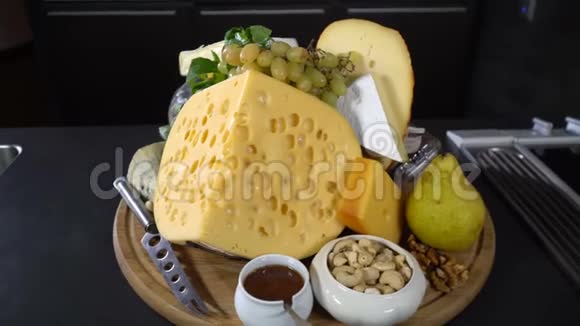 桌上有坚果和水果的奶酪种类视频的预览图