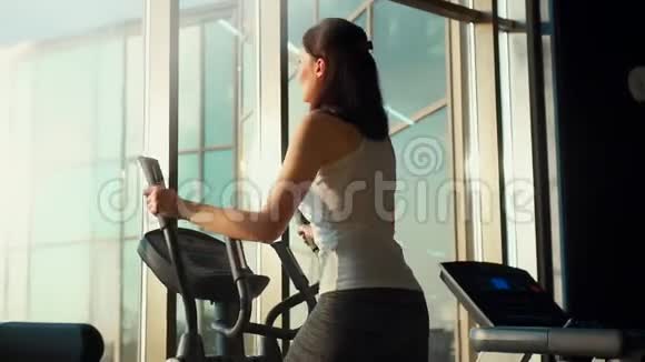 时髦健身房跑步机上的苗条女孩阳光视频的预览图