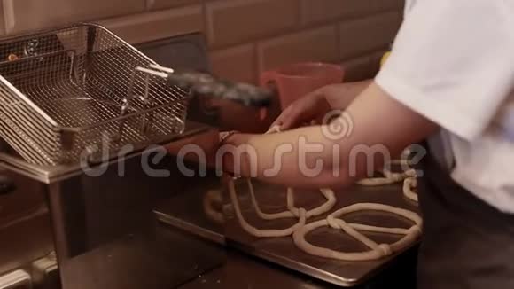 女人在面包店里用向日葵和芝麻做新鲜的椒盐脆饼视频的预览图