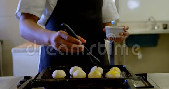 厨师在厨房的面团上涂油视频的预览图