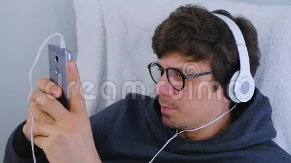 人类在智能手机上用耳机听音乐用卡拉OK唱一首歌放松时间视频的预览图