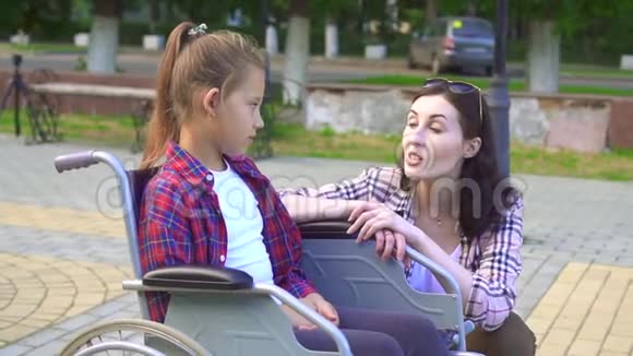 坐在轮椅上和女孩说话的残疾青少年慢节奏视频的预览图