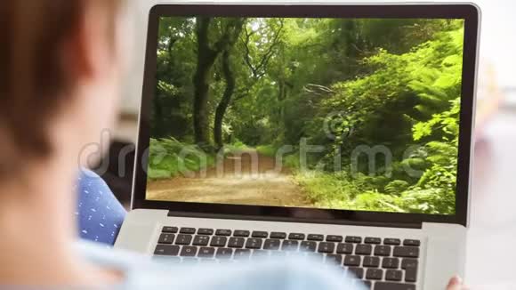 在森林里用笔记本电脑的女人视频的预览图