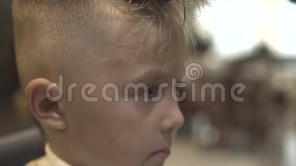 儿童理发店的肖像小男孩可爱的小男孩而孩子们在美发沙龙理发关门视频的预览图