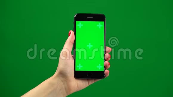 女性手握绿色屏幕上最新智能手机视频的预览图