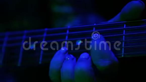 女性的手被夹住电吉他弦音乐会灯光特写镜头视频的预览图