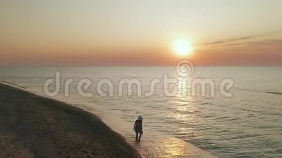 日落时一个女人在海边散步的美丽场景快乐快乐的女孩放松表现出快乐和幸福视频的预览图