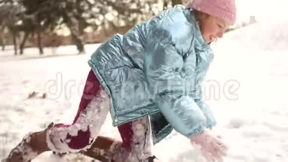 微笑的女孩在公园里享受寒冷阳光的早晨活泼可爱的女学生正拿着雪球对着镜头视频的预览图