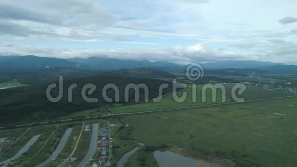空中无人机在绿色草地上看到美丽的自然风景有河流和软管背景是山脉视频的预览图