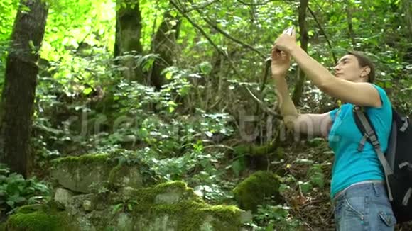 女博主旅行者用智能手机拍摄绿色热带雨林视频视频的预览图