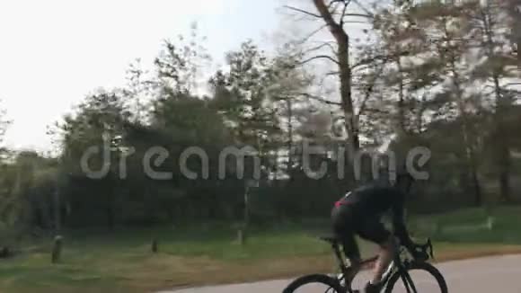 骑自行车的人从马鞍上向上坡冲刺道路自行车培训后面跟着射击视频的预览图
