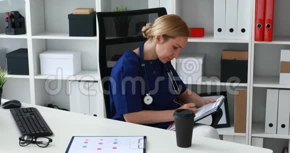 穿蓝色制服的医生在相机上做笔记视频的预览图