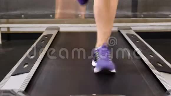 迷人的20年代健身俱乐部的跑步机上的女性脚福利概念步行道交叉配合4k视频的预览图
