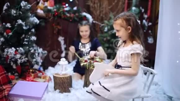 一个女孩骑着一匹木马在一棵圣诞树旁孙女们把一条白色的披肩作为礼物送给心爱的人视频的预览图