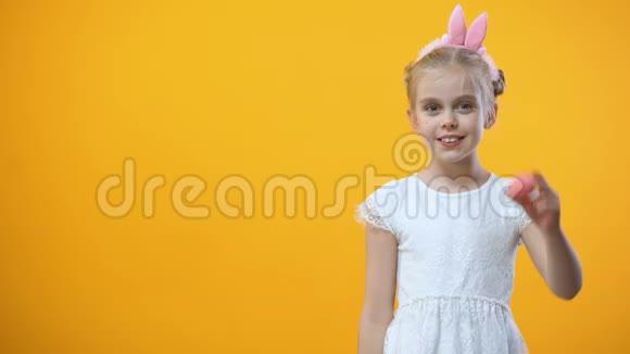 嬉戏的女孩子眼前拿着彩蛋复活节的象征节日视频的预览图