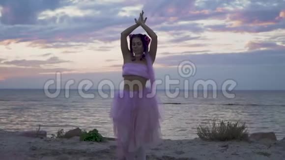 嫩嫩的年轻女子化着闪闪发光的妆容穿着一件粉红色的连衣裙在河岸上翩翩起舞甜美性感的舞蹈视频的预览图