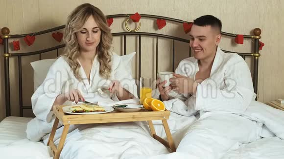 年轻情侣床上浪漫早餐视频的预览图