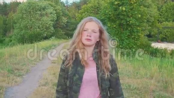 一个十几岁的女孩走在森林边享受着大自然的早晨这孩子有一头金发她微笑着视频的预览图