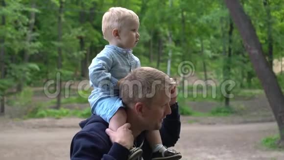 快乐的小男孩站在爸爸肩膀上视频的预览图