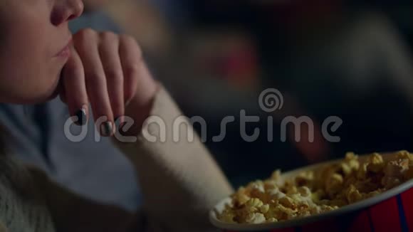 女孩把爆米花从纸桶带到嘴里在电影院吃玉米的女人视频的预览图