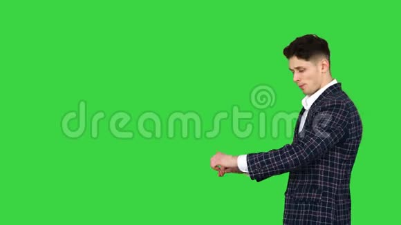 年轻酷雅的男人走在绿色的屏幕上铬钥匙视频的预览图