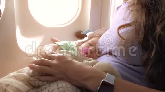 妈妈和她熟睡的宝宝乘飞机旅行视频的预览图