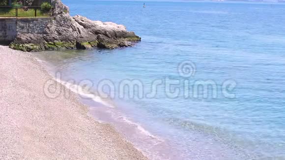 令人惊叹的海景海滩与蔚蓝的水黄沙和一个小岩石在角落的照片一个美丽的视频的预览图