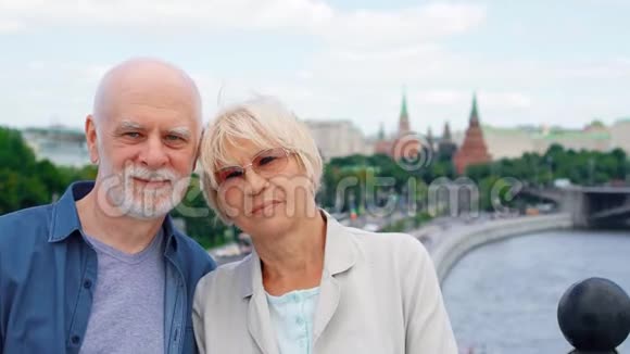 年长夫妇站在观察甲板上看着摄像机在俄罗斯莫斯科旅行的养老金领取者视频的预览图