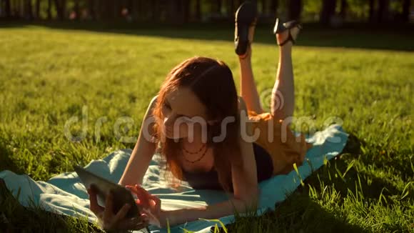 英俊的女人坐在草地上的公园里视频的预览图