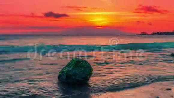 印度尼西亚隆博克森吉吉海滩上俯瞰大海大石头的日落视频的预览图