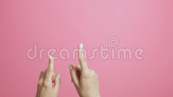 女孩手指举着女孩在粉红工作室的背景上积极打手势视频的预览图