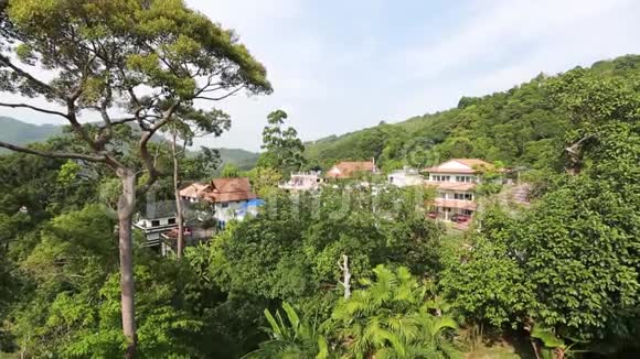 泰国普吉阳光明媚的白天亚洲城市彩色房屋棕榈树和天空的景色视频的预览图