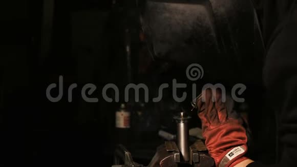 一个焊接工厂的男工人戴着焊接面罩在工业厂房上焊接视频的预览图