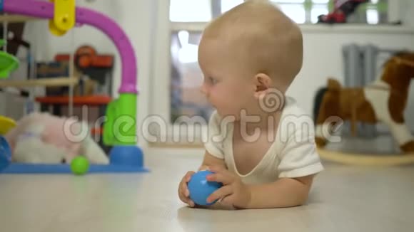快乐可爱的幼儿手里拿着玩具看着相机在室内爬进特写镜头视频的预览图
