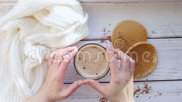 早餐加卡布奇诺和自制煎蛋饼在一张木桌2女孩双手拧着一杯咖啡视频的预览图