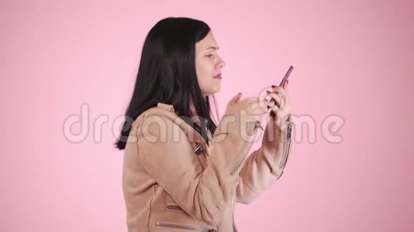 愤怒的现代女商人慢吞吞地叫着放下手机穿着粉色衣服沮丧的女孩视频的预览图