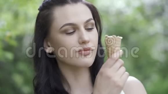 可爱的女人在公园里吃冰淇淋视频的预览图