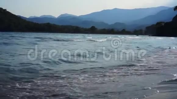 海浪在沙滩上背景是山脉视频的预览图