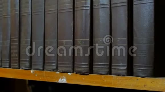 图书馆书架上一排大的旧黑书视频的预览图