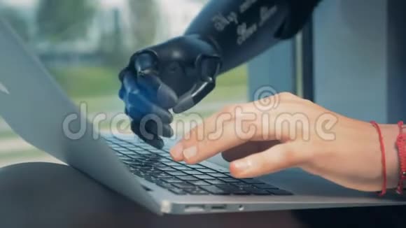 男人用笔记本电脑工作戴着仿生手cyborg概念视频的预览图