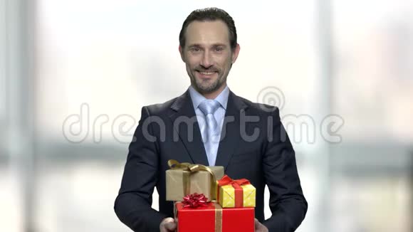 微笑的商人拿着一堆礼品盒视频的预览图